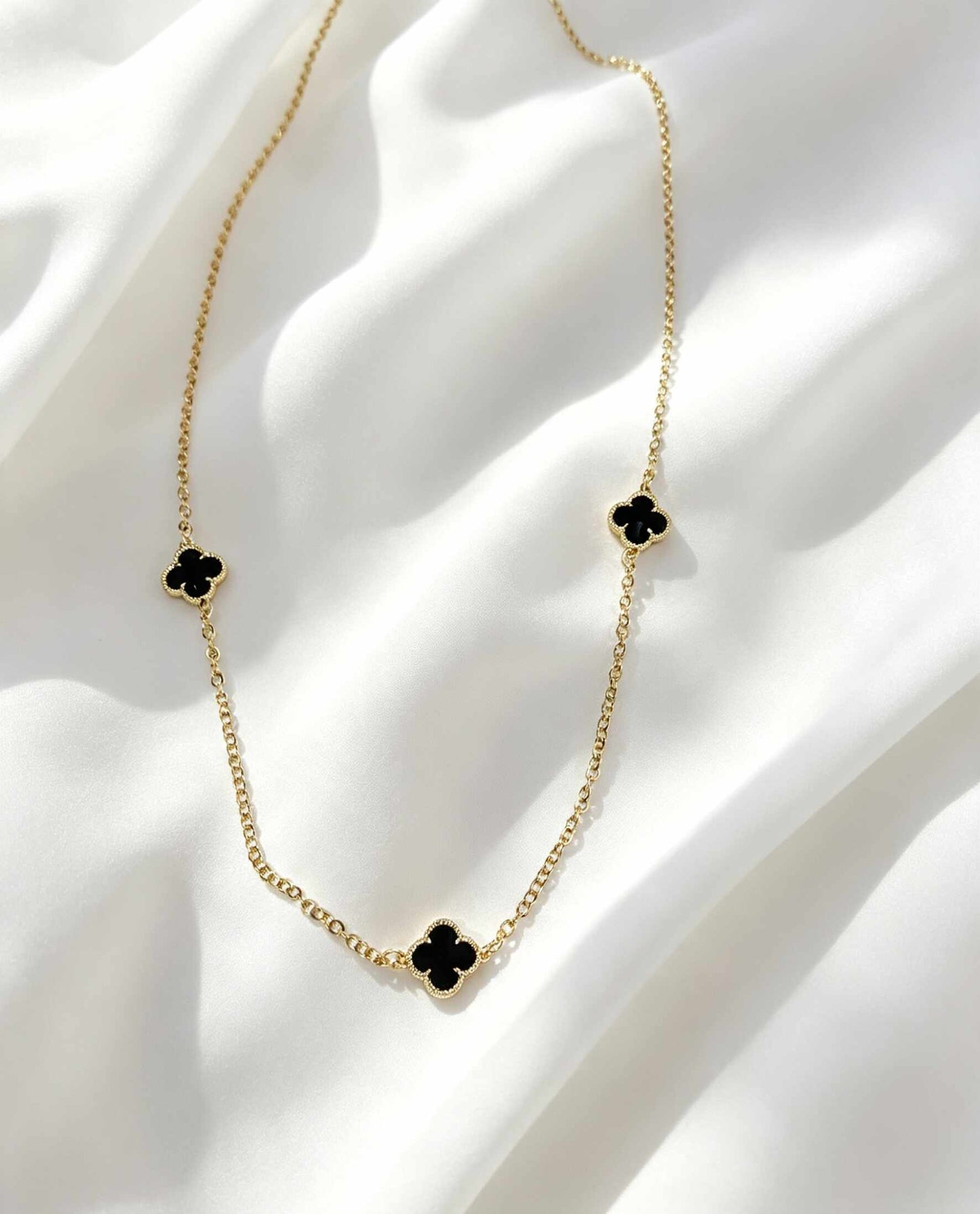 Collar largo con tres dijes de trébol negro