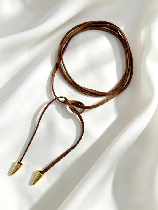 Cordón marrón, diseño minimalista y versátil de tiras largas que permite enrollarlo varias veces al cuello.