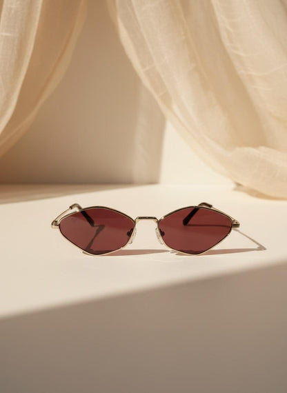 Su diseño fino y lentes en tono rojizo crean un look moderno y lleno de actitud. Perfecto para convertir un outfit simple en uno inolvidable.