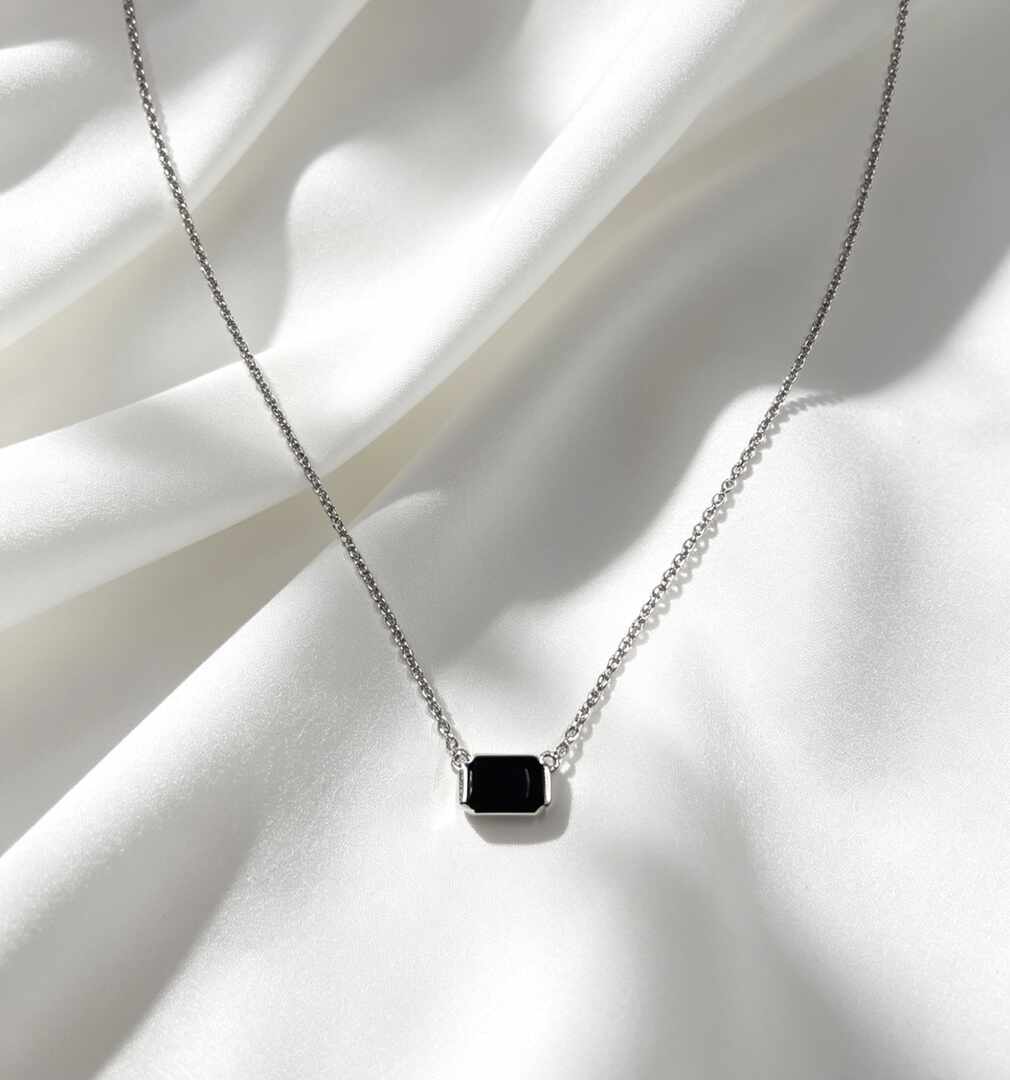 collar con un dije rectangular de piedra negra