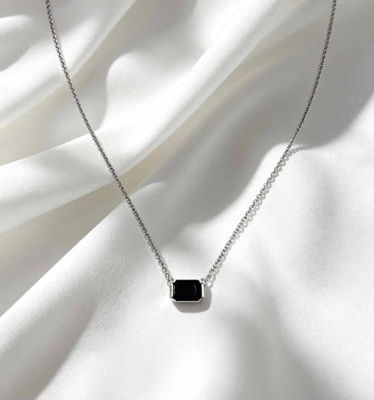 collar con un dije rectangular de piedra negra