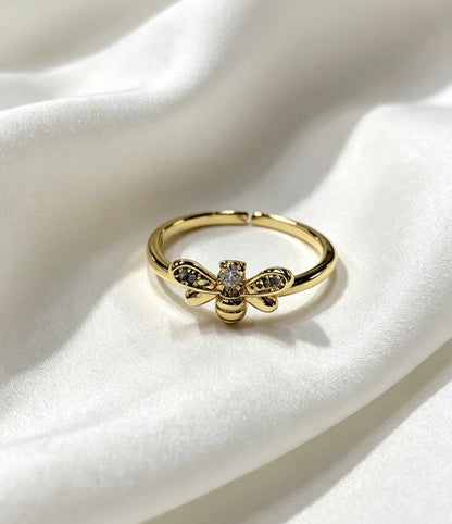 Anillo ajustable con diseño de abeja, adornado con microcirconias en sus alas y una circonia central más grande..