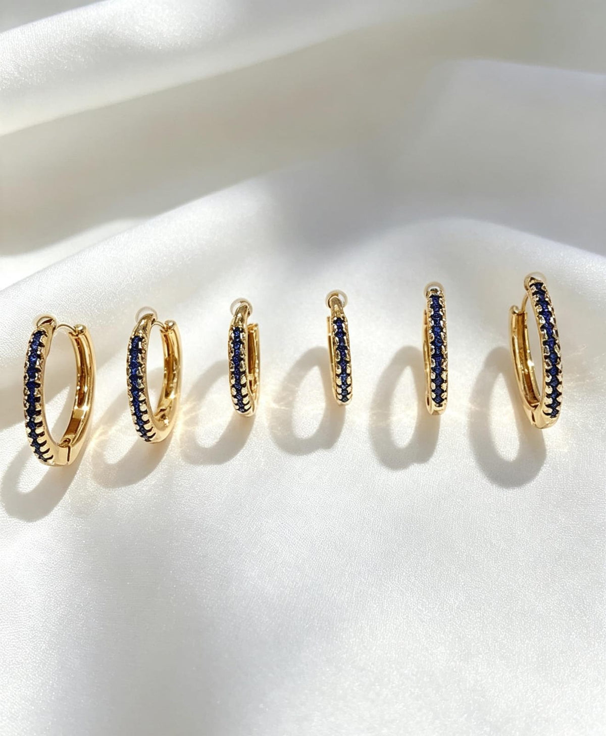 Trio de aritos con microcirconias azul en oro